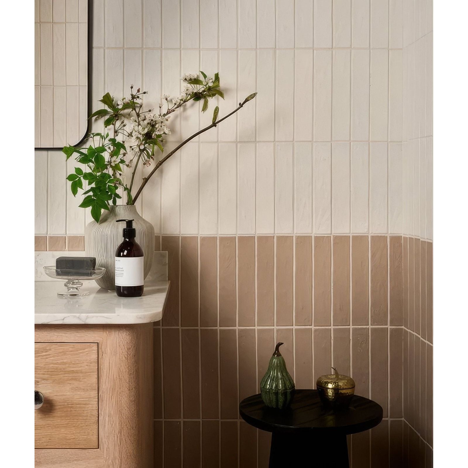 A sleek matte-finished earthenware porcelain plaster vase with ribbed texture holding white blossoms and greenery