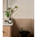 A sleek matte-finished earthenware porcelain plaster vase with ribbed texture holding white blossoms and greenery