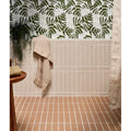 Beige earthenware porcelain plaster towel with frayed edges and subtle horizontal stripes hanging on tiled wall