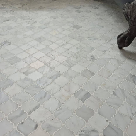 White marble mosaic tiles in an east hampton arabesque pattern with quatrefoil design and subtle gray veining
