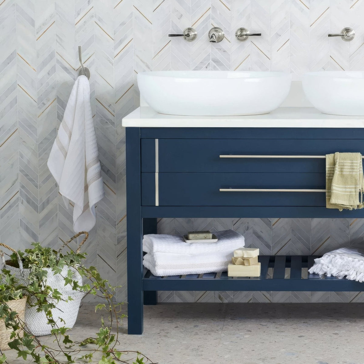 East Hampton Marble Chevron Mosaic white marble and gold chevron mosaic on a navy vanity with white vessel sinks