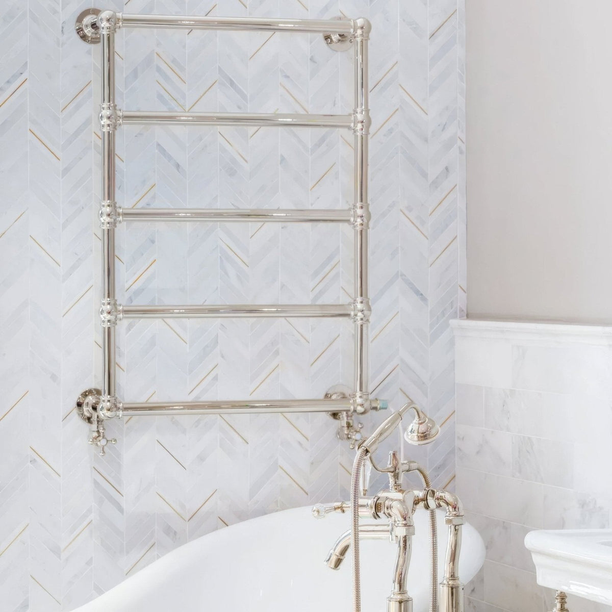 East Hampton Marble Chevron Mosaic white marble and gold chevron mosaic with a chrome heated towel rail