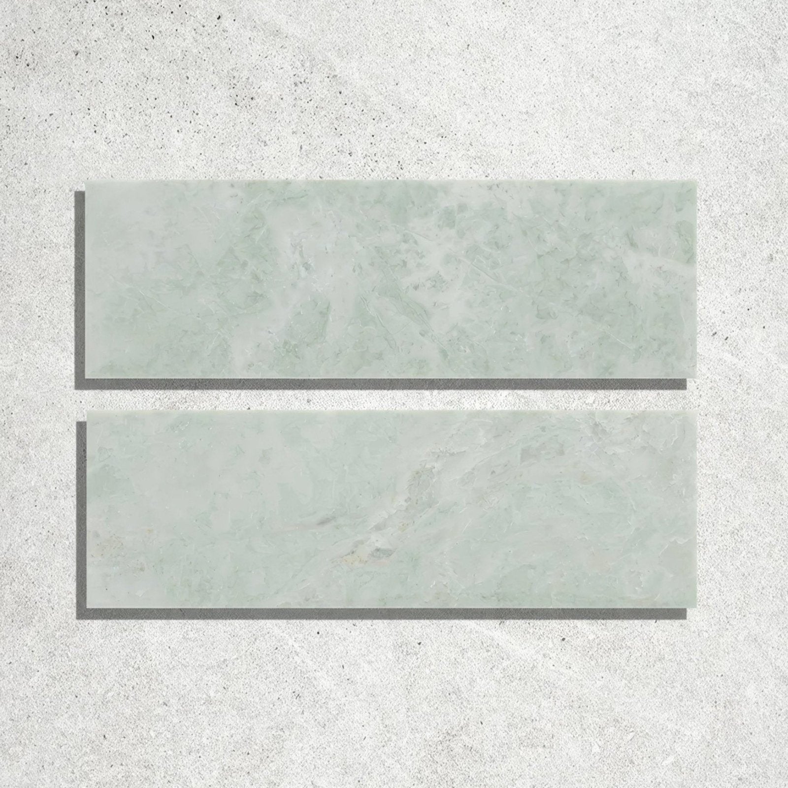 Two rectangular light green marble effect honed bricks with subtle veining from east java hummingbird marble