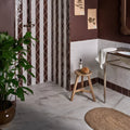 East Village Porcelain Bianco 30 x 30cm off-white marble-effect porcelain tile with a wooden three-legged stool