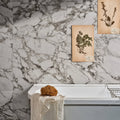 East Village Porcelain Grigio 60 x 60cm grey marble-effect porcelain tile with a loofah and towel on a white bathtub