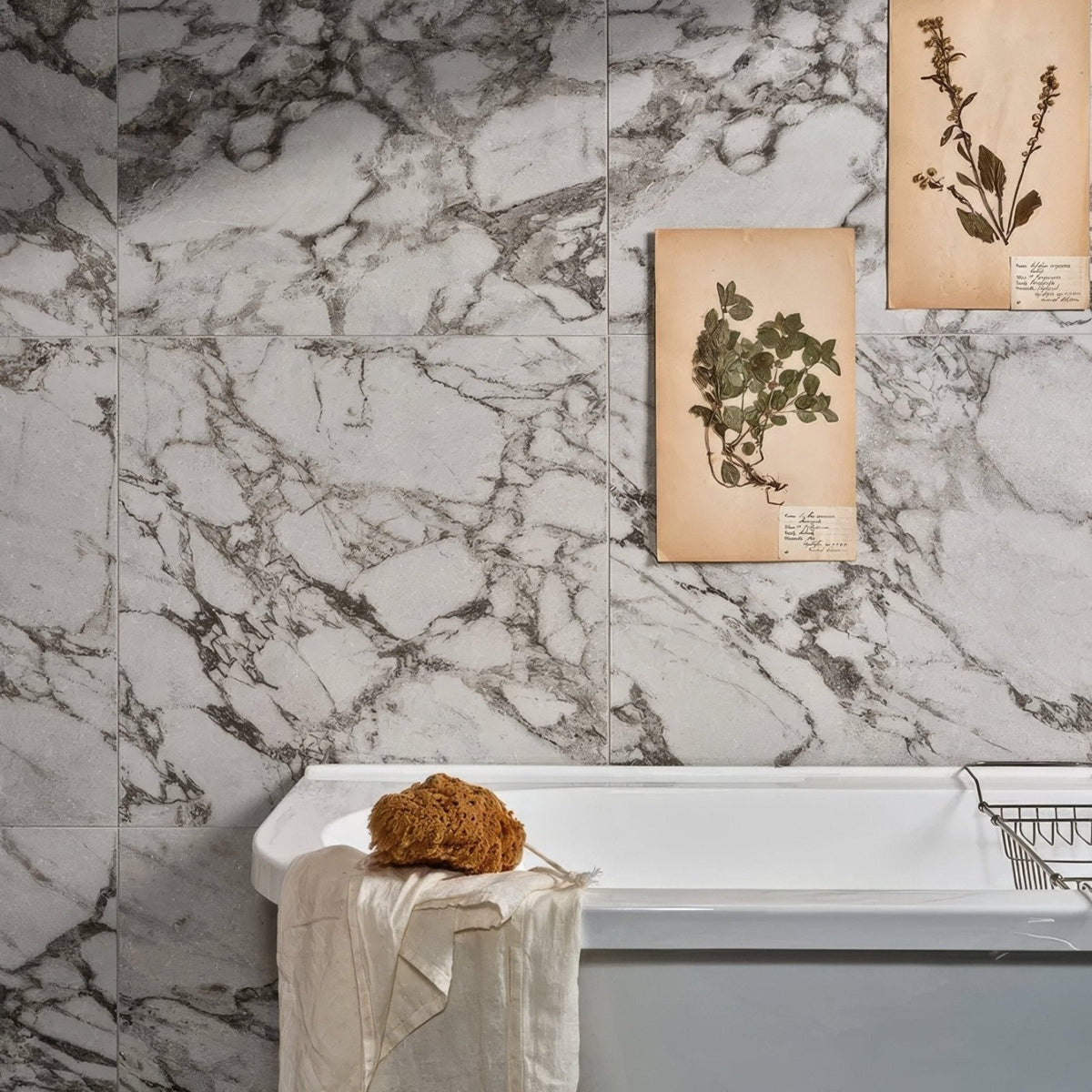 East Village Porcelain Grigio 60 x 60cm grey marble-effect porcelain tile with a loofah and towel on a white bathtub