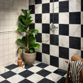 East Village Porcelain Nero 60 x 60cm black marble-effect porcelain tile with a fiddle leaf fig in a beige pot