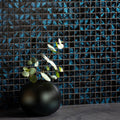 Eden Glass Mosaic blue and black iridescent glass mosaic with a black vase of eucalyptus