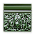A glossy forest green ceramic Edwardian Caledonian dado tile with intricate raised floral patterns and a decorative border