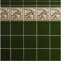 Edwardian green astragal moulding featuring dark green ceramic tiles with decorative hand-painted fruit and floral border