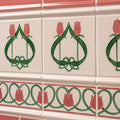 White ceramic tiles with pink and green art nouveau tulip motifs in a repeating pattern from elysée border vintage white