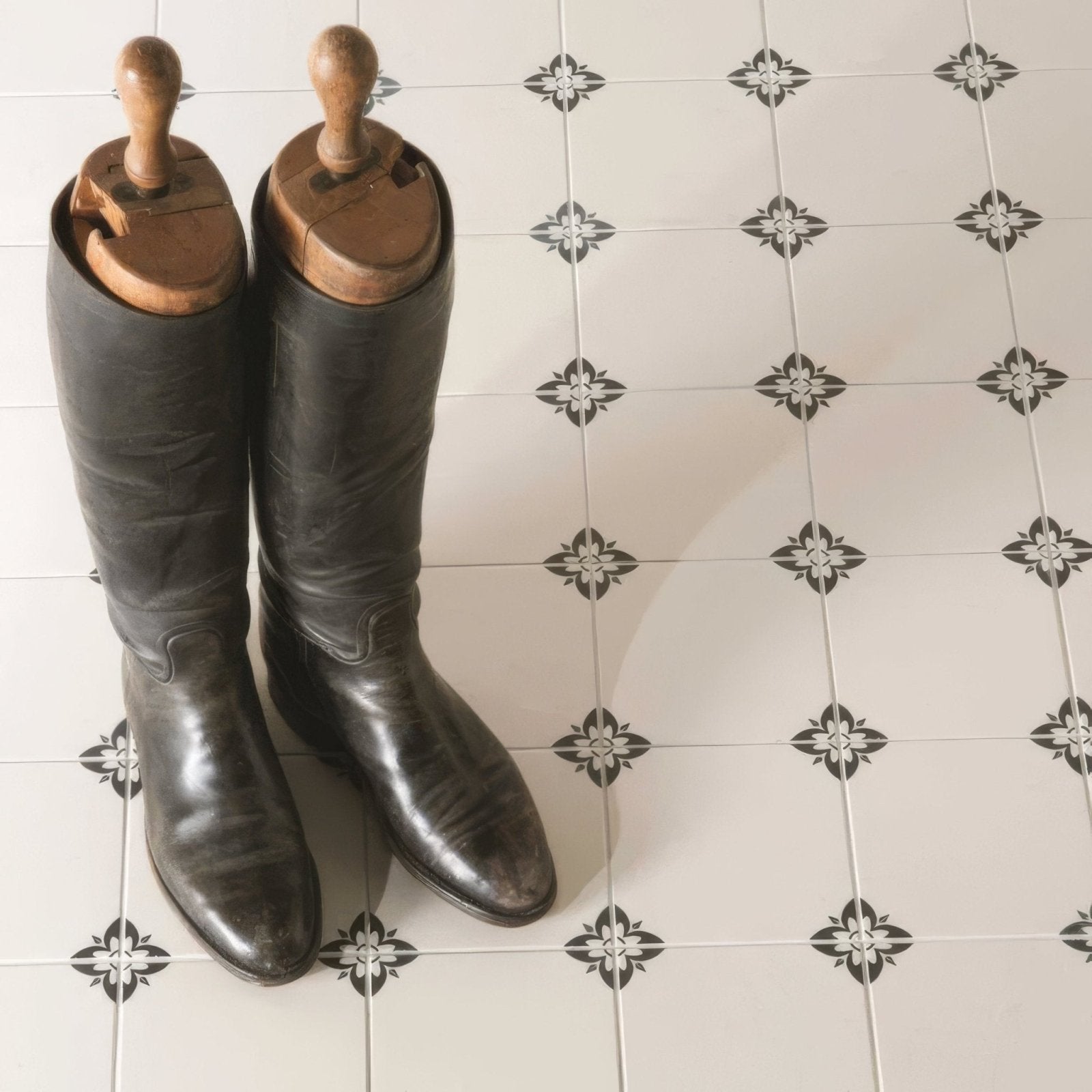 A pair of empire black polished leather riding boots with wooden shoe trees on a dover white background
