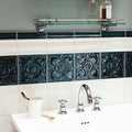 Deep teal ornate ceramic empress dado tourmaline tiles with raised floral patterns adorning bathroom wall
