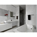 Energy Stone Pietragrey White white marble-effect tiles with a modern bathtub and chrome fixtures