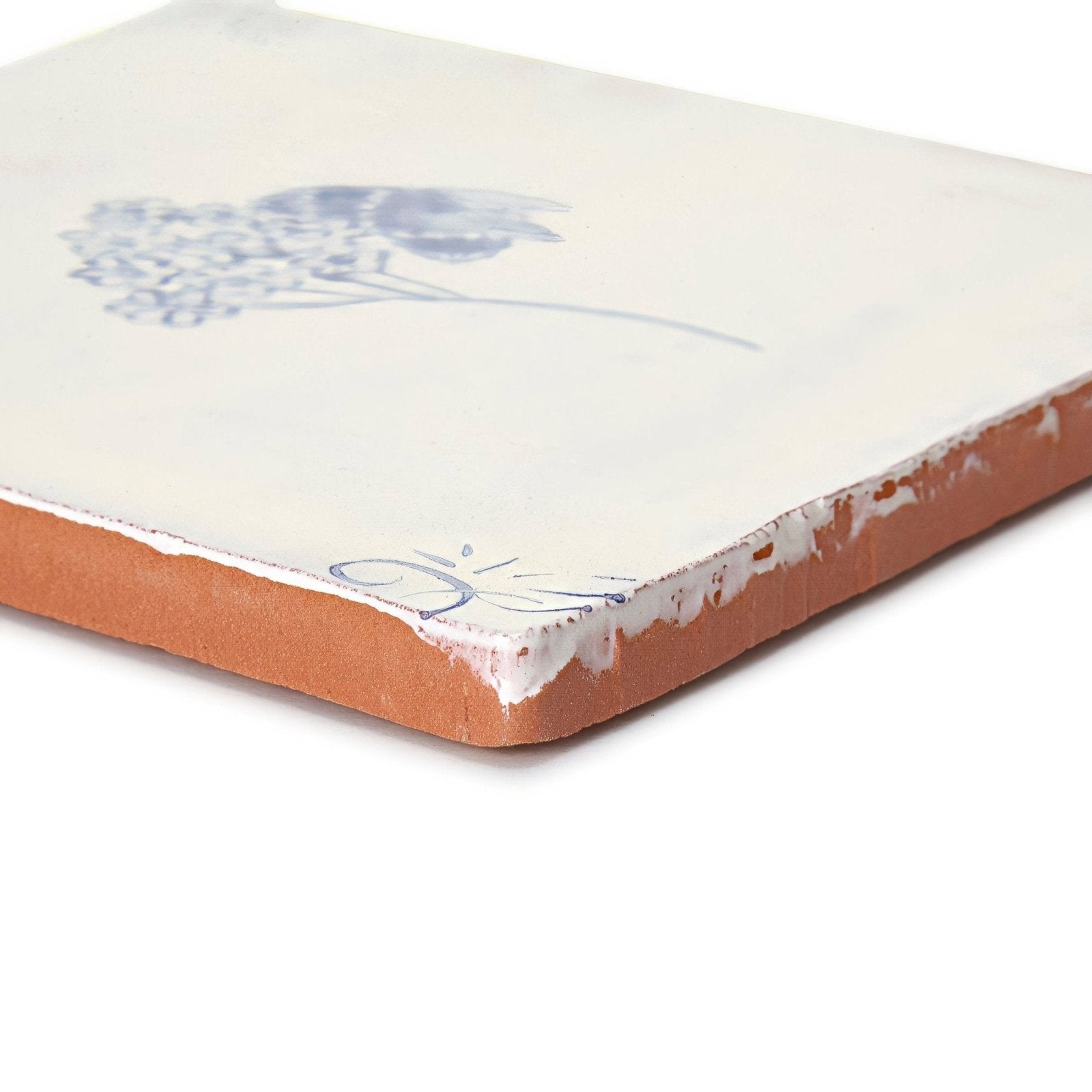 Cream-colored English Delft Bee Blue gloss ceramic tile with delicate blue floral design and exposed terracotta edges