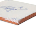A square ceramic english delft butterfly 2 blue gloss tile with white glaze blue floral design and terracotta edge