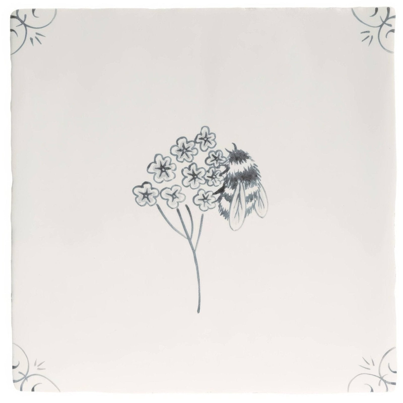 A cream-colored ceramic English Delft charcoal bee tile with a hand-drawn black ink bumblebee and floral design