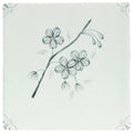A delicate black ink sketch of a flowering branch on a pale green ceramic tile english delft charcoal blossom
