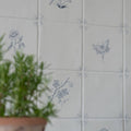 White ceramic English Delft charcoal tulip tiles with delicate gray floral and butterfly decals