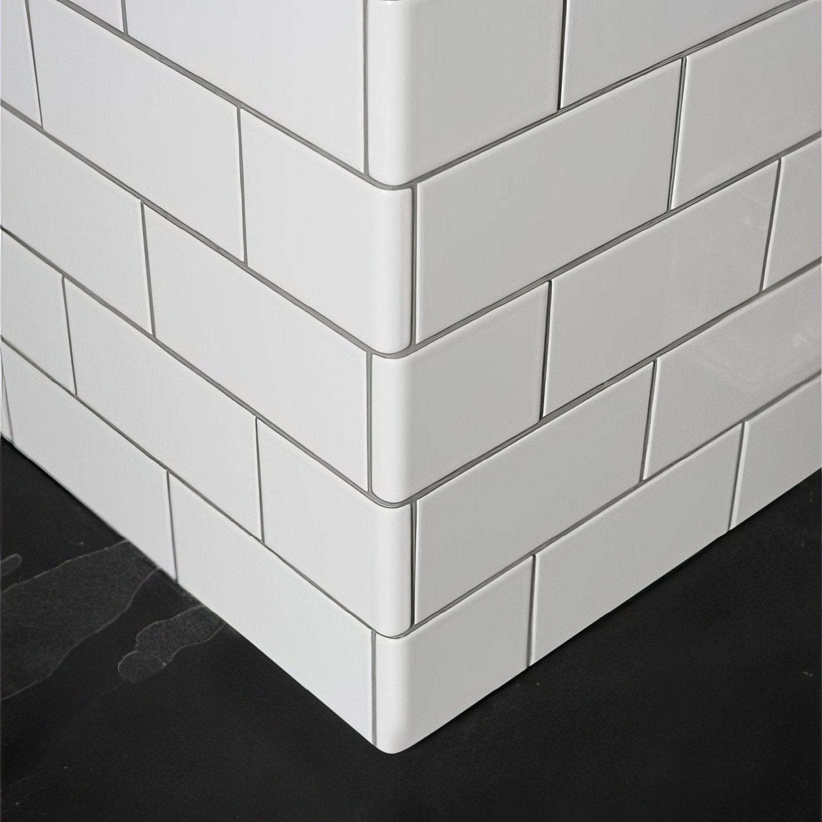 External half tile wrapping piece brilliant white with glossy white subway tiles and thin gray grout lines
