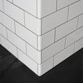 External half tile wrapping piece brilliant white with glossy white subway tiles and thin gray grout lines