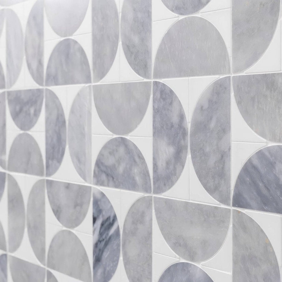 Gray marble tiles with circular geometric pattern set in white grout figure spiral light mosaic design