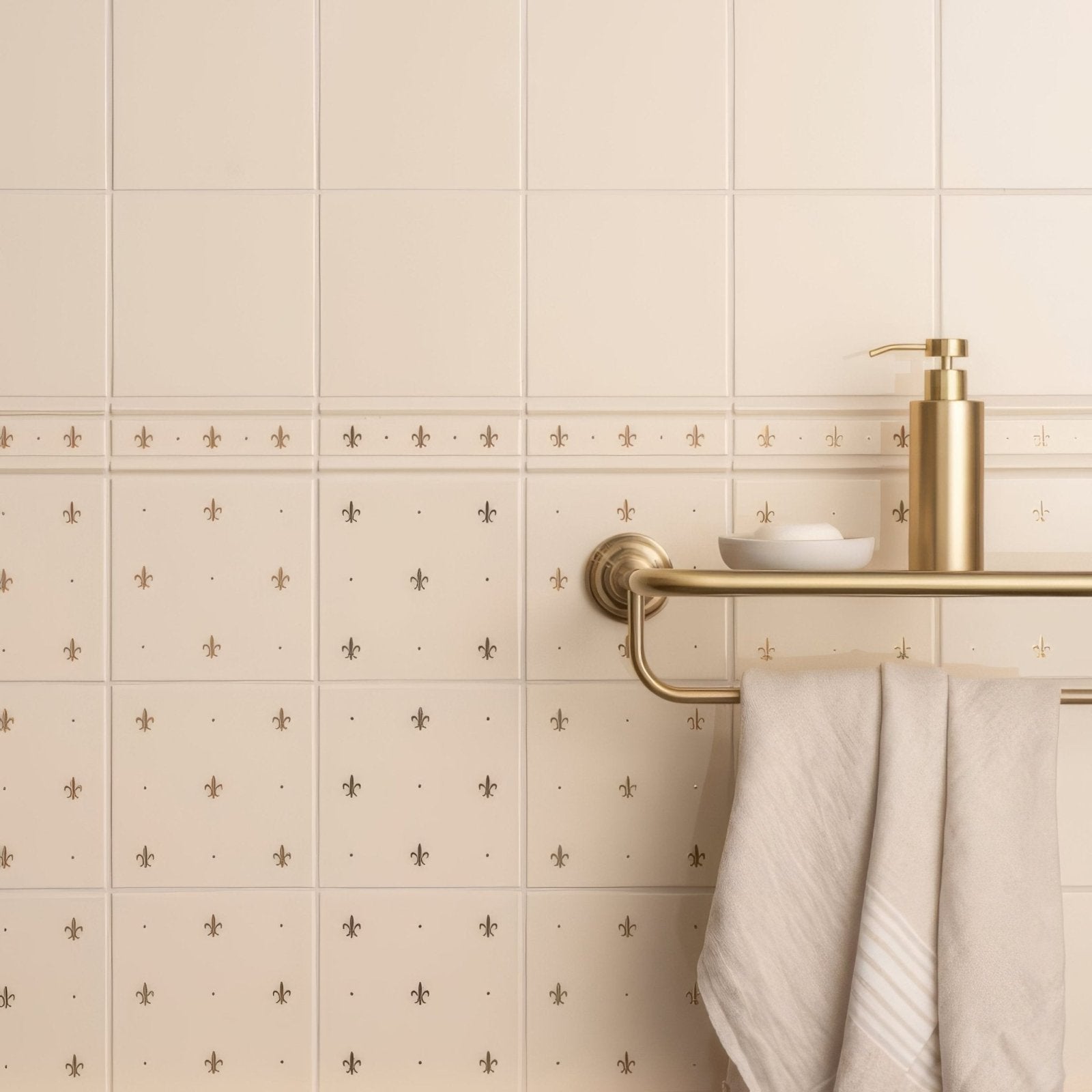 Cream-colored ceramic tiles with subtle gold fleur de lis patterns in fleur de lis border gold on county white design