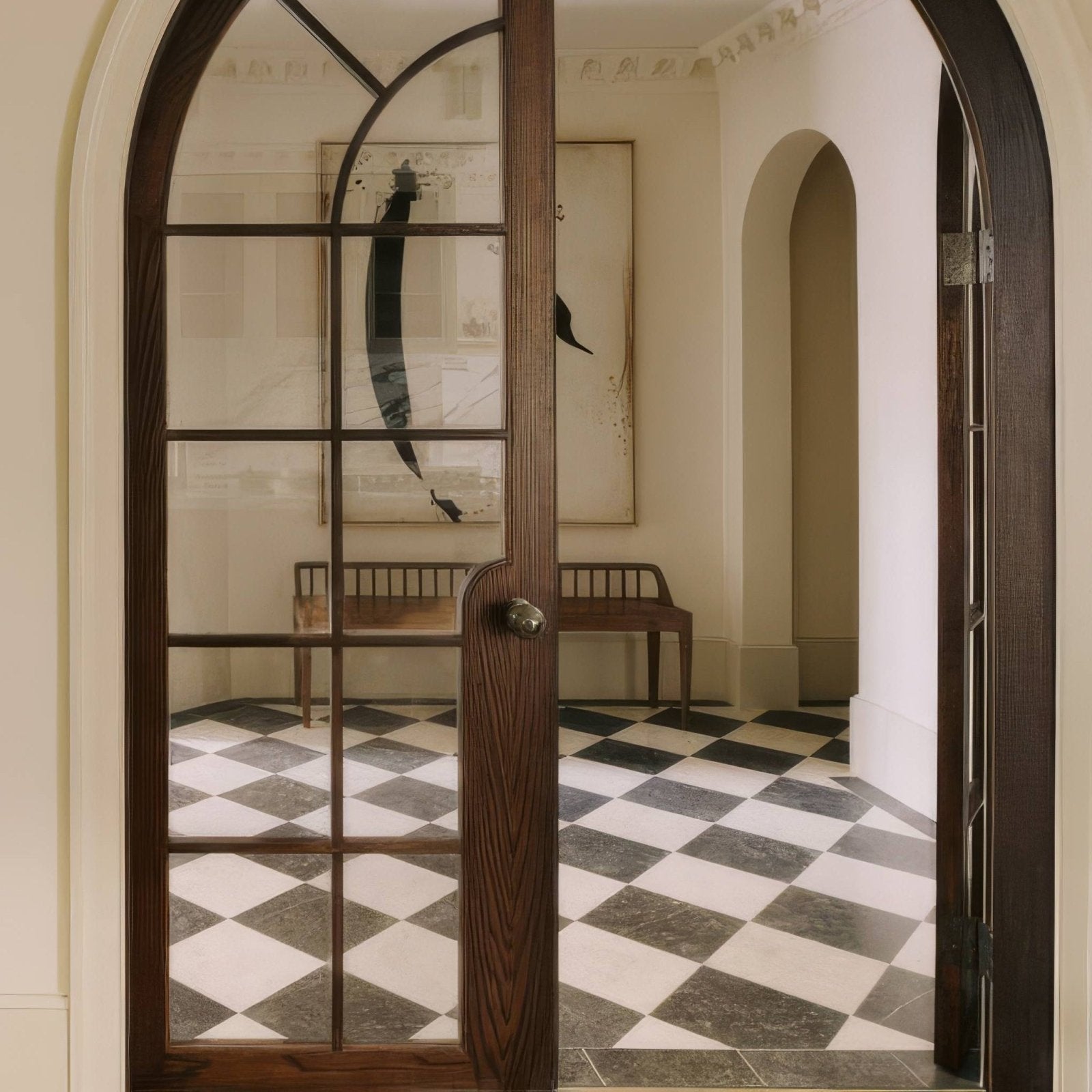 Dark wood arched door with glass panes and metallic handle shown alongside folio marble honed finish 61 x 61cm tile