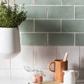 Forecast arran square glazed tile in matte muted sage green with subtle texture and white grout lines backsplash