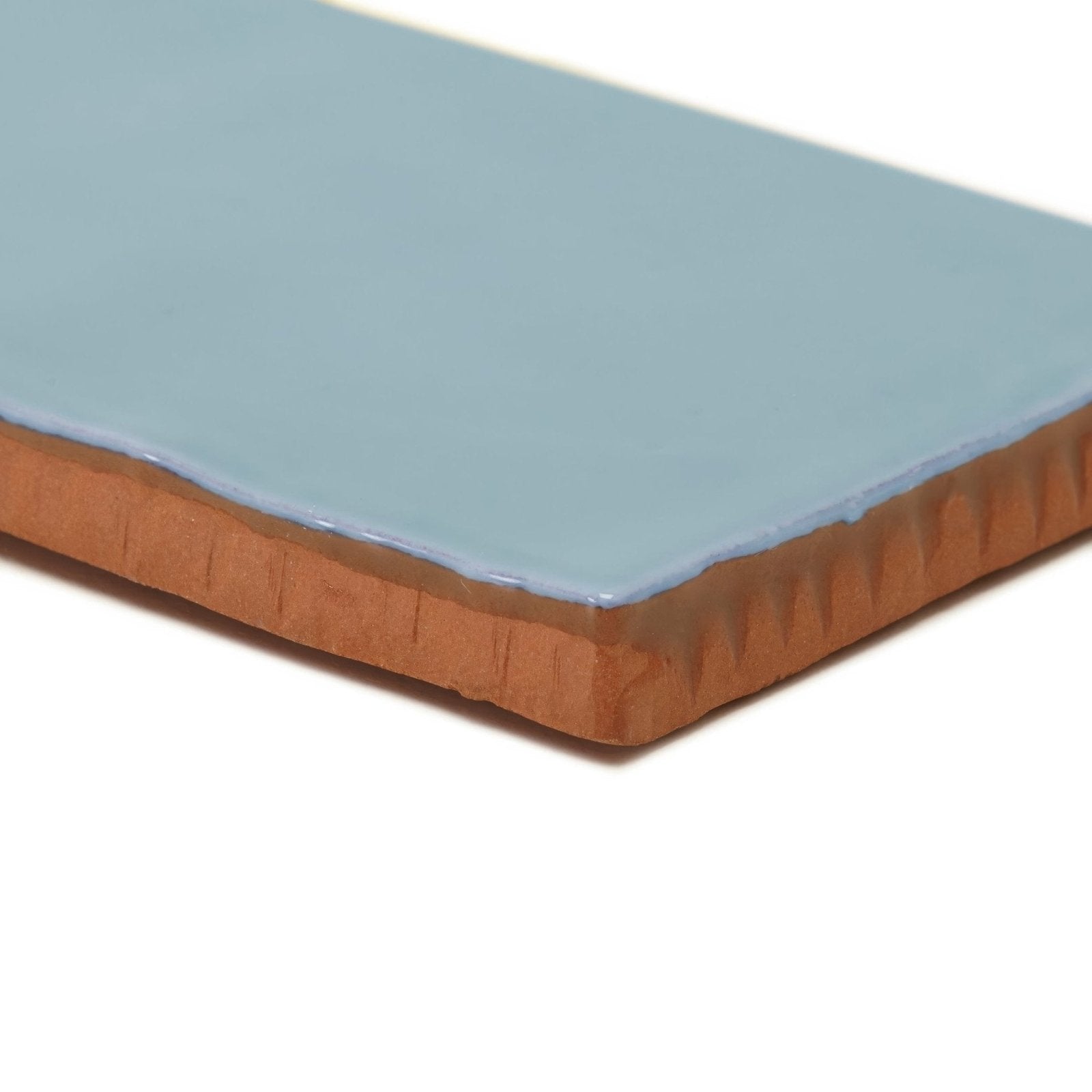 A rectangular Forecast Forth glazed ceramic tile with smooth light blue surface and exposed terracotta ridged edges