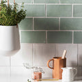 A white ceramic hanging planter with sleek modern design holding green herbs for the forecast rockall rectangle glazed tile