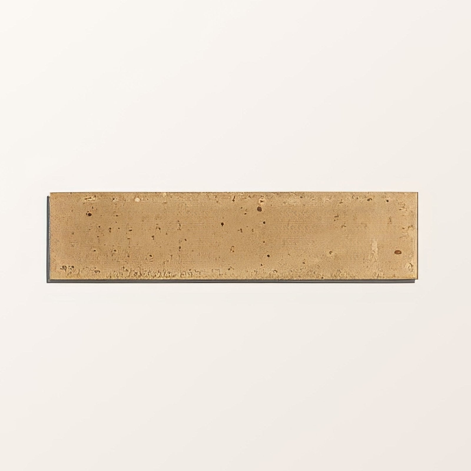 A rectangular matte-finished brass tile with subtle speckled texture from foundry novo porcelain beige collection