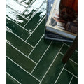 Deep green foundry novo porcelain tiles with glossy finish arranged in a herringbone pattern