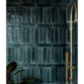 Dark teal rectangular ceramic tiles with glossy textured finish forming a wall in foundry novo porcelain navy design