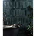 Foundry novo porcelain navy dark green glossy textured rectangular tiles behind black clawfoot bathtub wall panel