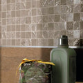 Four Seasons Sand Mosaic beige and white marble-effect mosaic with a sage green bottle and wrapped soap