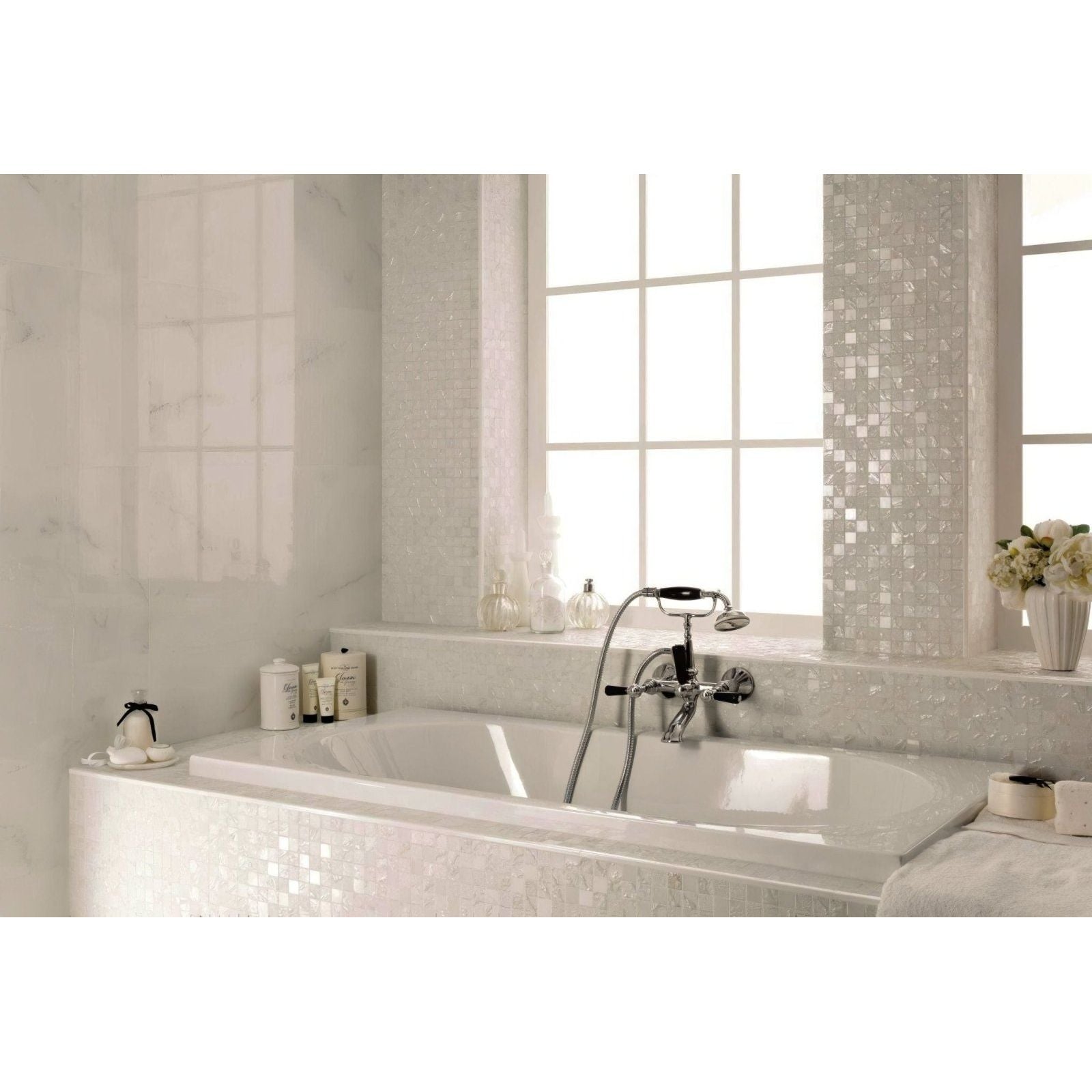 White marble bathtub with chrome faucet and four seasons snow mosaic tile accents