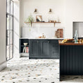 Dark gray shaker-style kitchen cabinets with recessed panel doors and round brass knobs paired with frammento multi terrazzo effect porcelain tile