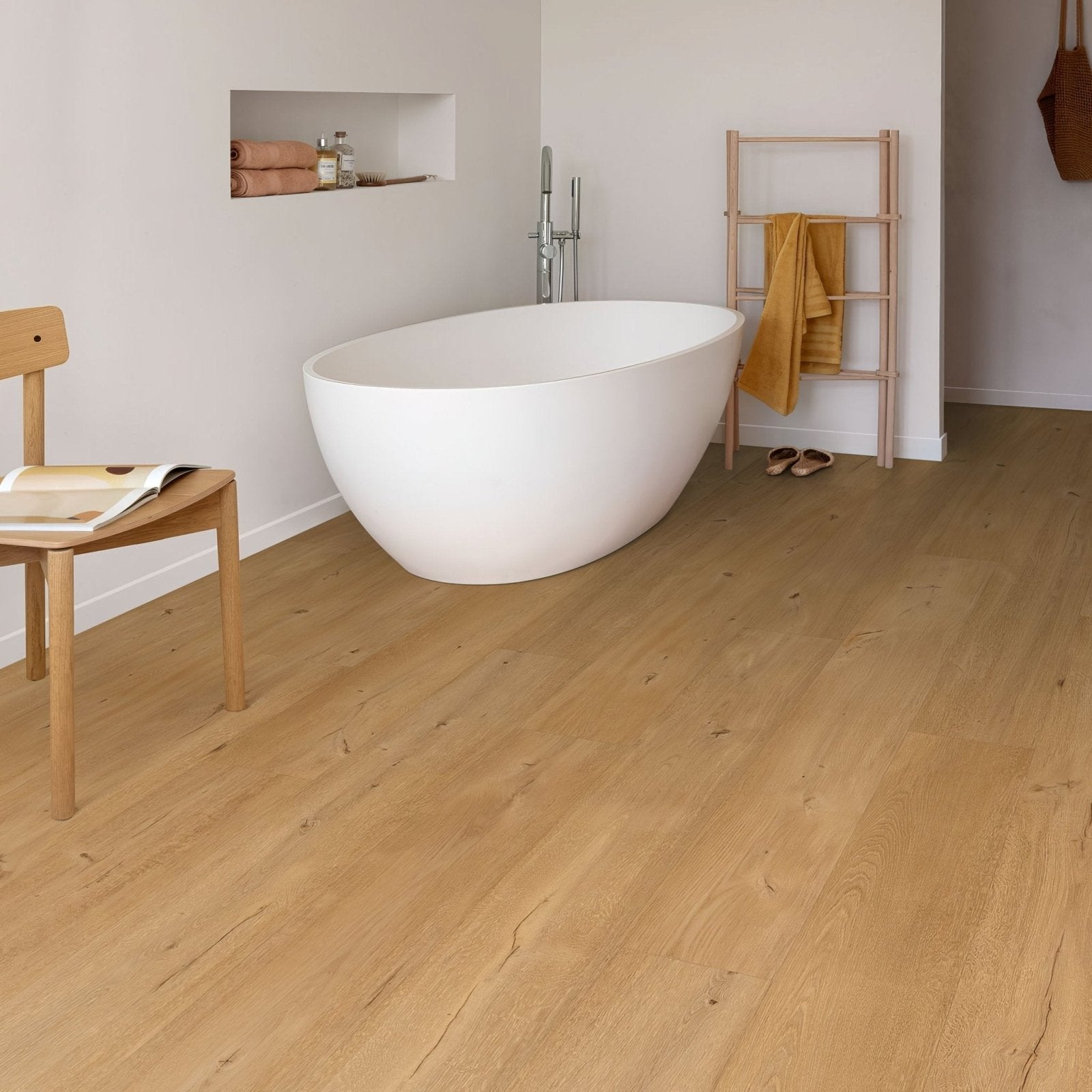 White freestanding bathtub with smooth rounded edges and minimalist design beside frangipane f095 xl vinyl planks
