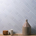 A matte-finished taupe ceramic vase with a flared neck and tapered body displayed on frost smooth brick tile