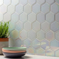 Futura Dichroic Hexagon Mosaic iridescent blue and grey hexagon mosaic with a stack of three ceramic bowls