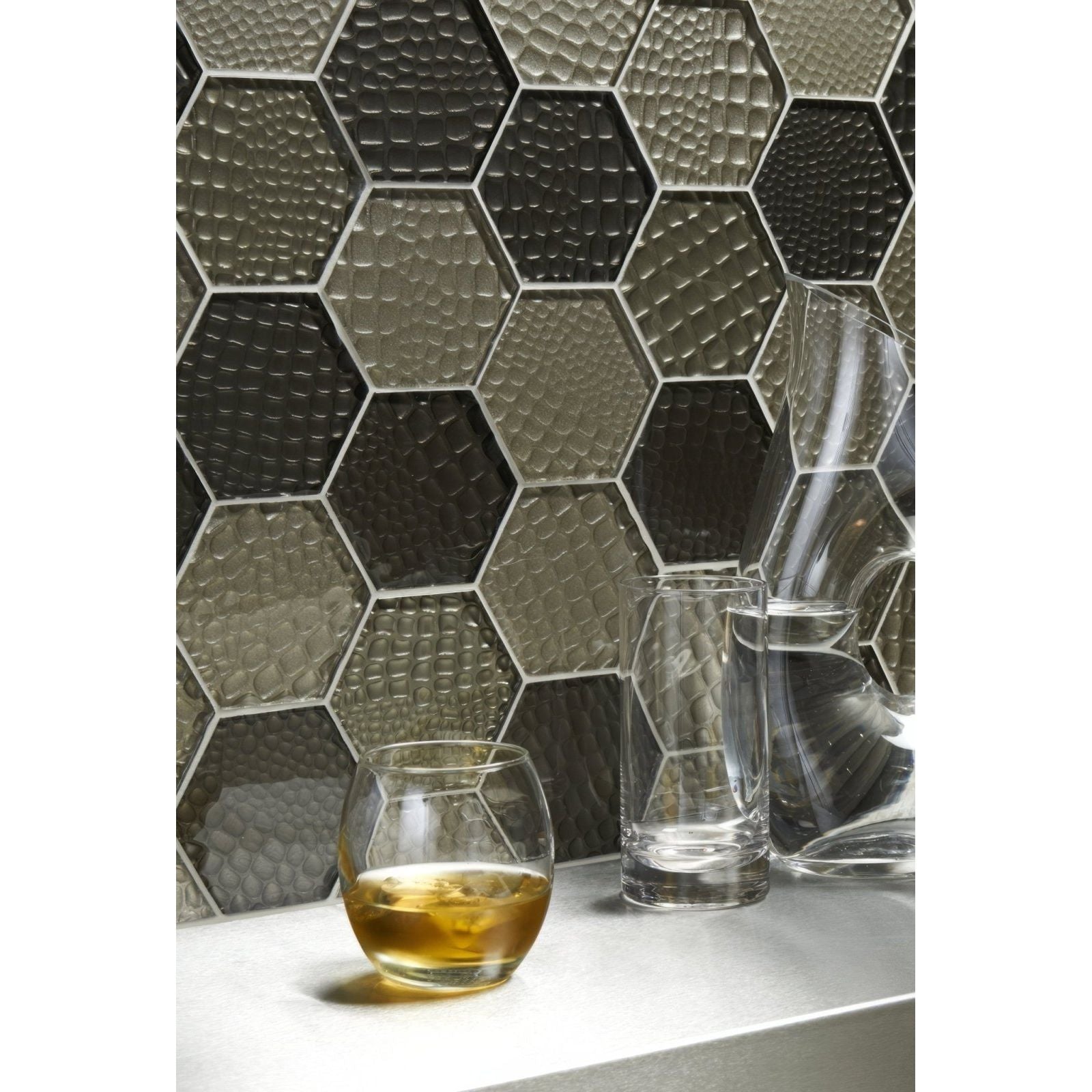 Futura Sepia Hexagon Mosaic grey and black hexagon mosaic with a faceted glass tumbler of amber liquid