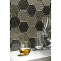 Futura Sepia Hexagon Mosaic grey and black hexagon mosaic with a faceted glass tumbler of amber liquid
