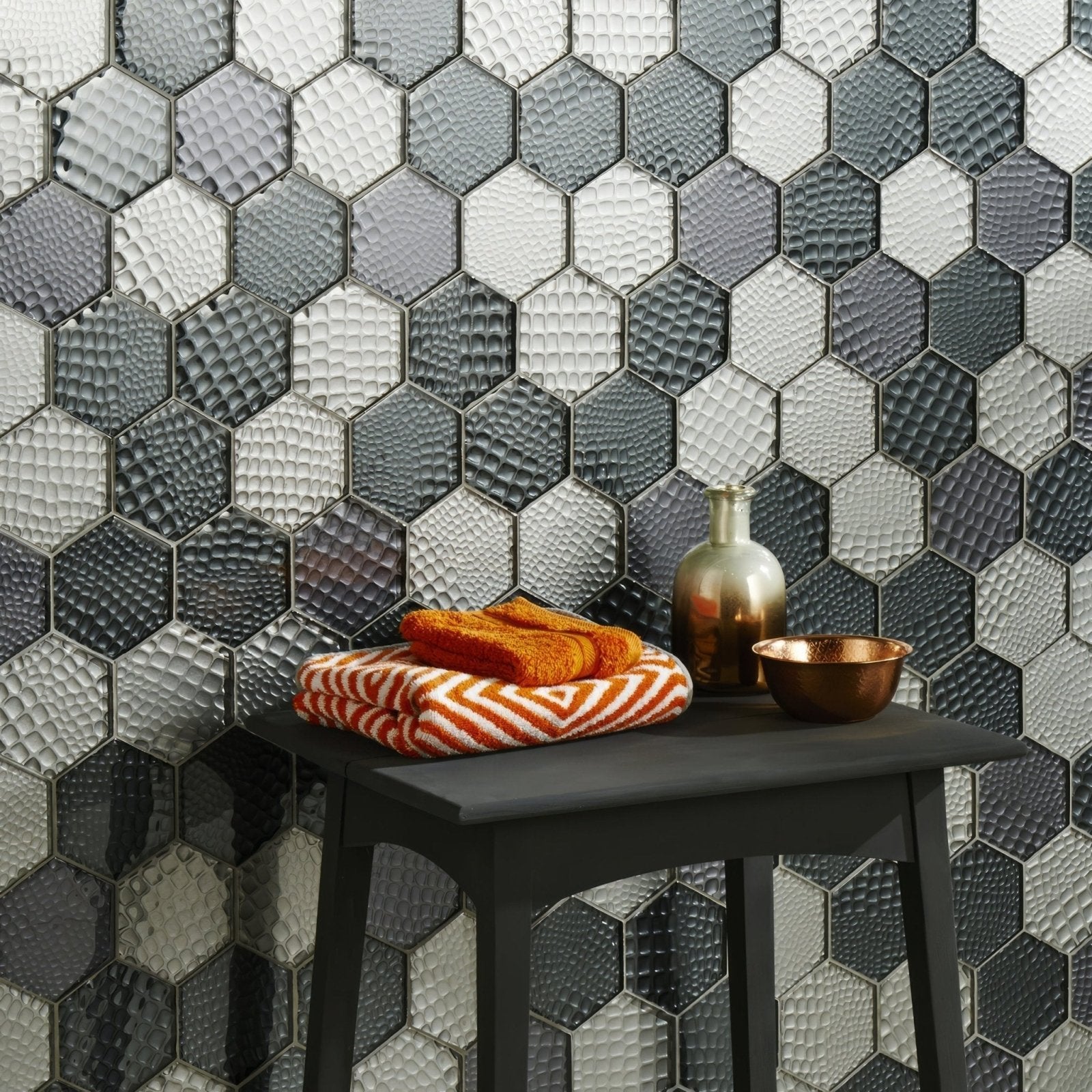 Futura Zirconia Hexagon Mosaic grey and white hexagon mosaic with a stack of orange striped towels