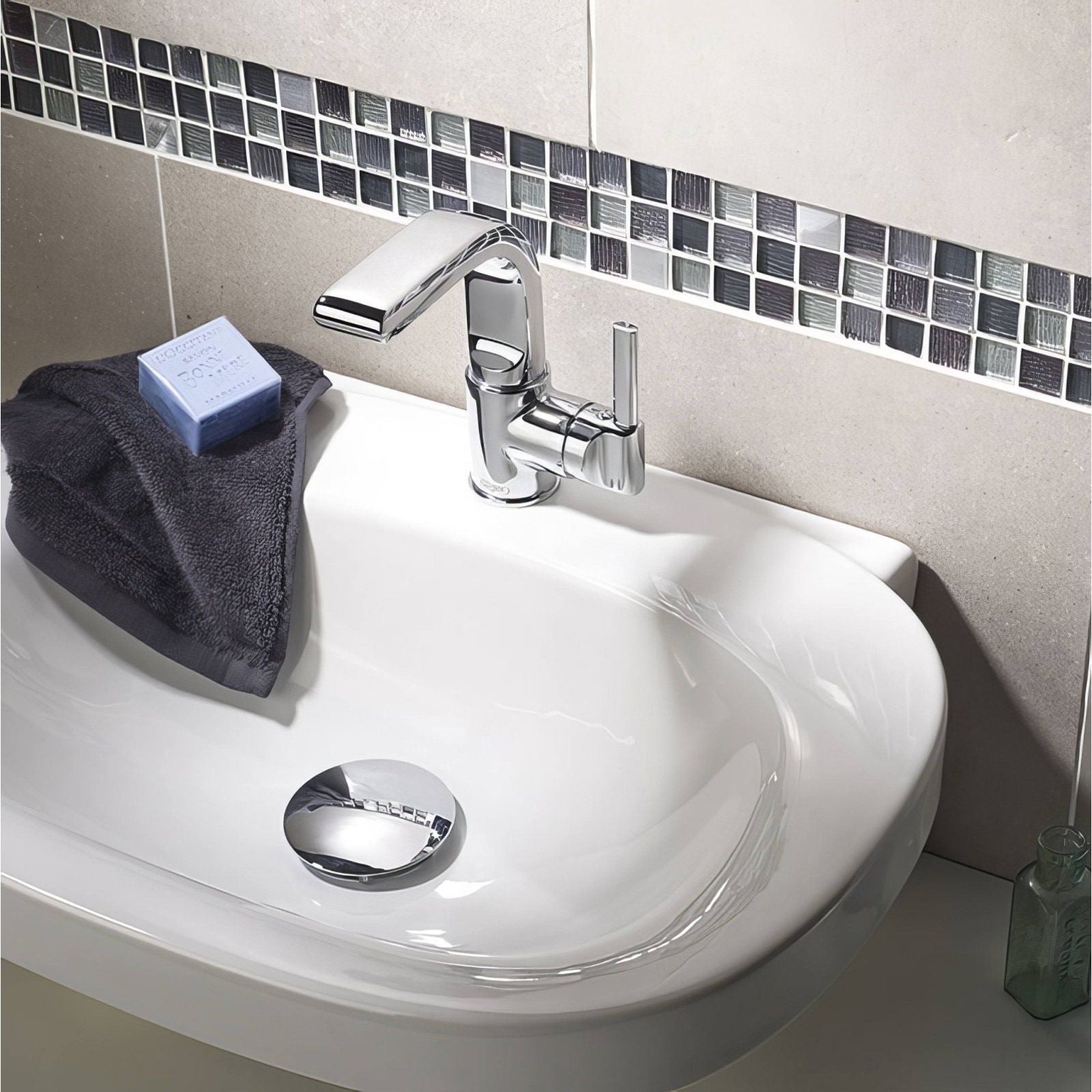 Galactic Black Glass & Metal Mix Mosaic dark grey and silver mosaic behind a white sink with a chrome tap