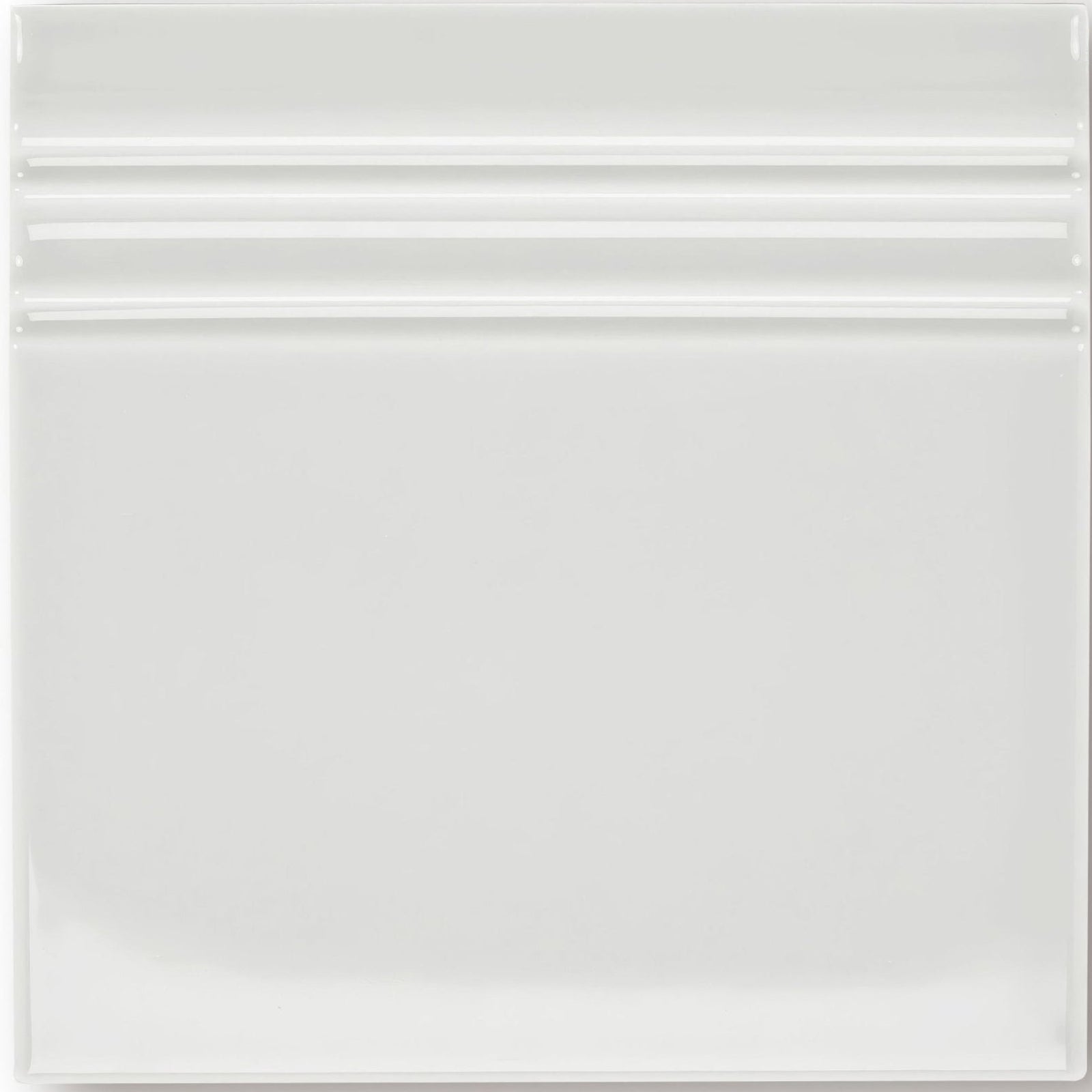 White ceramic giralda cascara cream skirting tile with a glossy finish and three horizontal ridges near the top