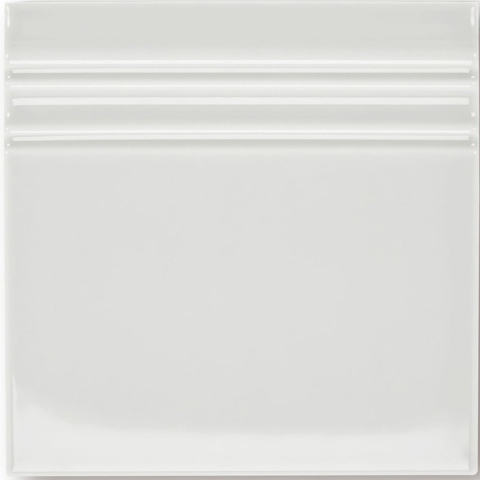 White ceramic giralda cascara cream skirting tile with a glossy finish and three horizontal ridges near the top