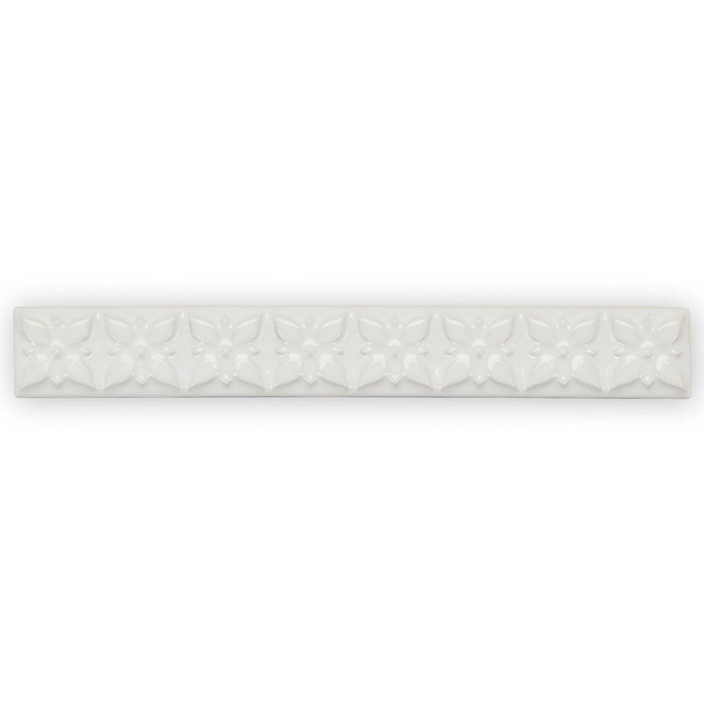 White ceramic tile giralda cascara cream trim with a repeating embossed floral pattern for wall decoration