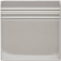 A sleek square ceramic giralda niebla grey skirting tile with a smooth glossy finish and three horizontal ridges near the top