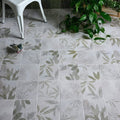 White glass house porcelain floor tiles with subtle gray and green leaf pattern on a white background